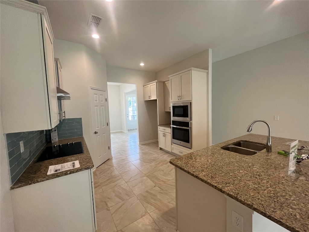 96754 Quartz Lane Yulee, FL 32097 - Photo 10 of 23 a kitchen with granite countertop a sink stove and refrigerator