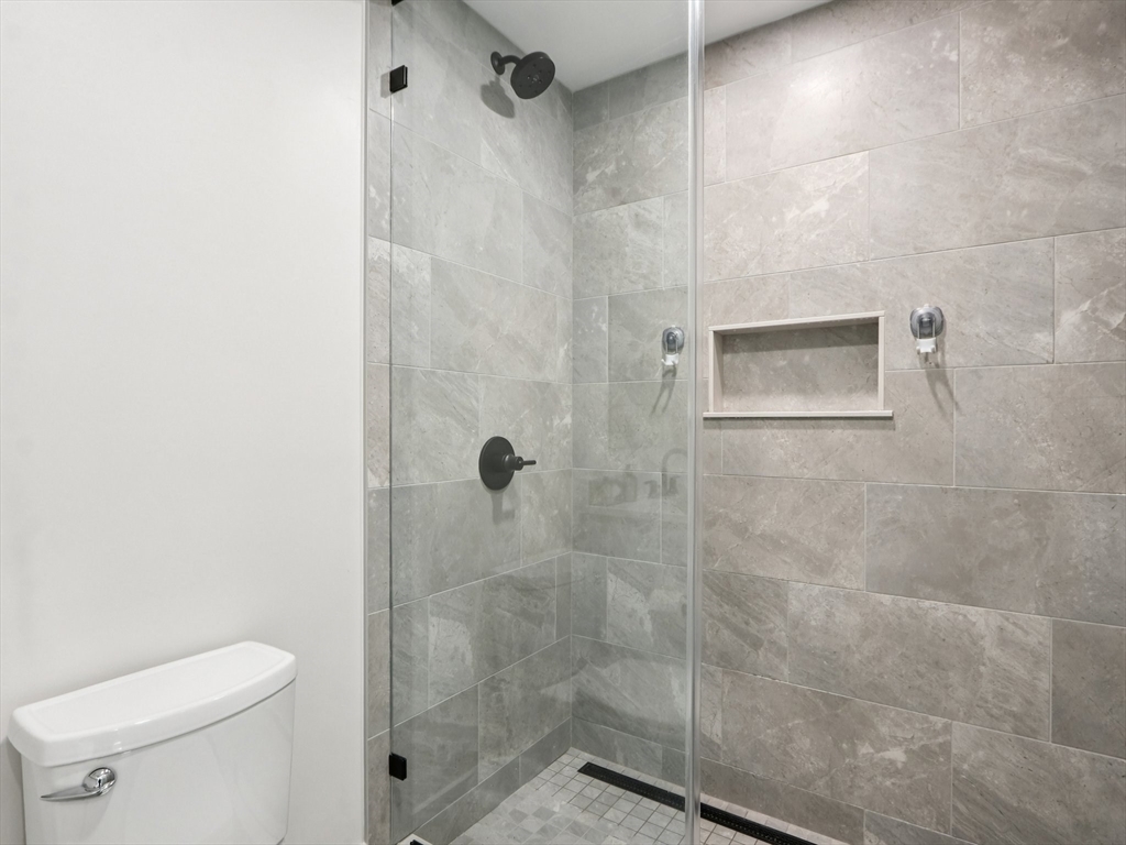 62 Foundry Street, Unit 204 Wakefield, MA 01880 - Photo 16 of 28 a bathroom with a shower a toilet and a sink