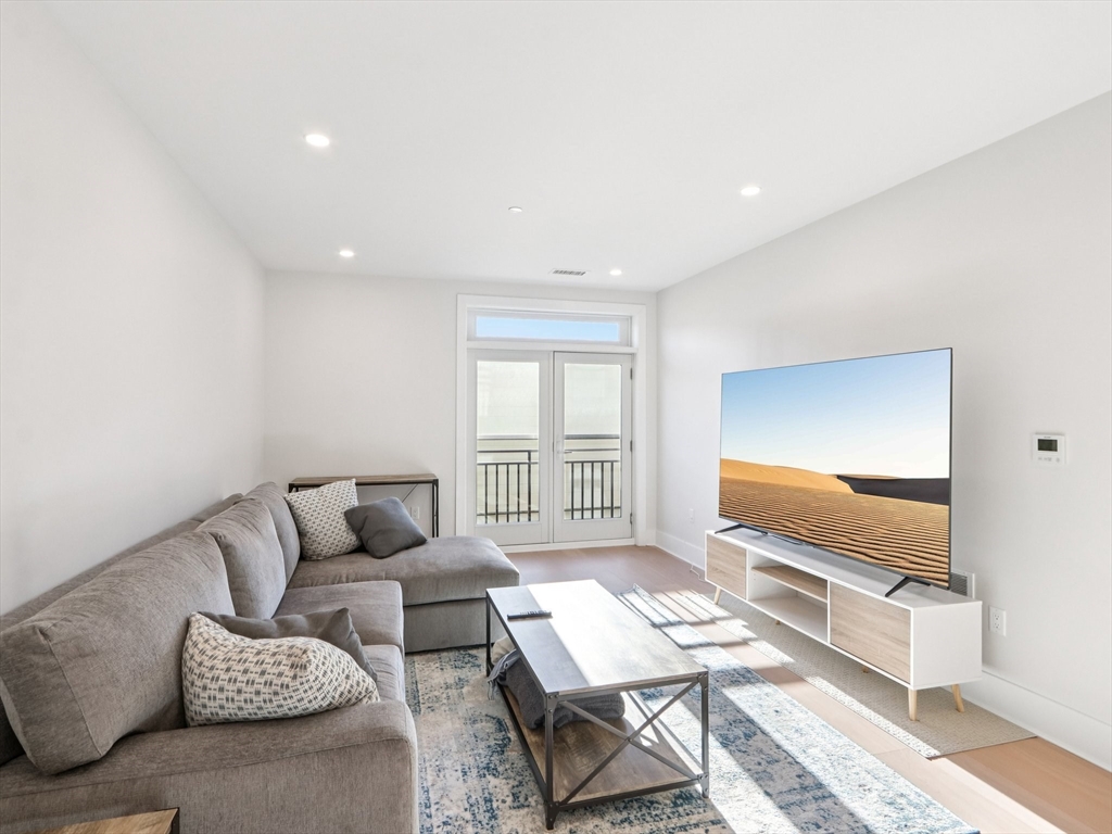 62 Foundry Street, Unit 204 Wakefield, MA 01880 - Photo 5 of 28 a living room with furniture and a flat screen tv