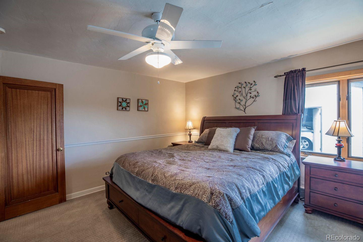 6101 South University Boulevard Centennial, CO 80121 - Photo 14 of 38 a bedroom with a large bed and a chandelier
