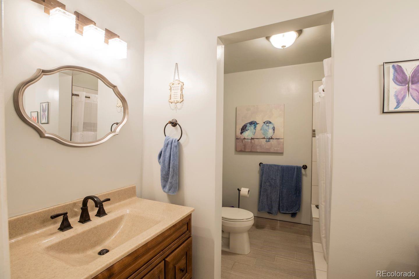 6101 South University Boulevard Centennial, CO 80121 - Photo 15 of 38 a bathroom with a sink mirror and toilet