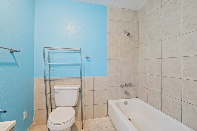 a white toilet sitting next to a bath tub