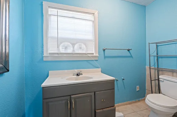 a bathroom with a sink a toilet and a mirror