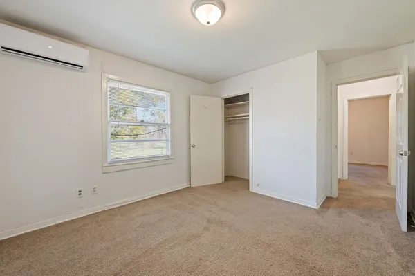 an empty room with windows and closet