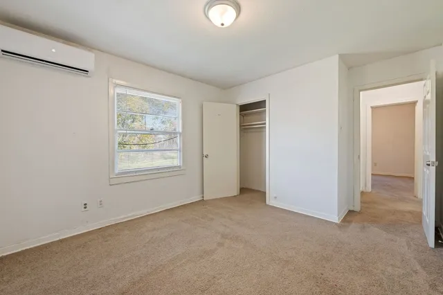 an empty room with windows and closet