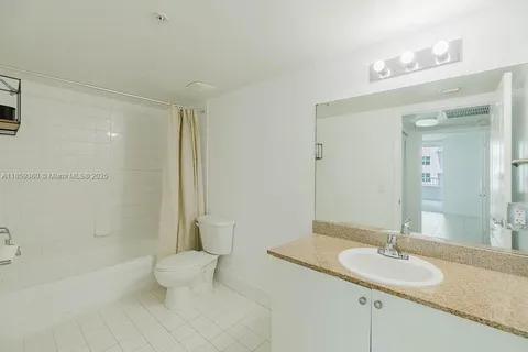 a white toilet sitting next to a bath tub