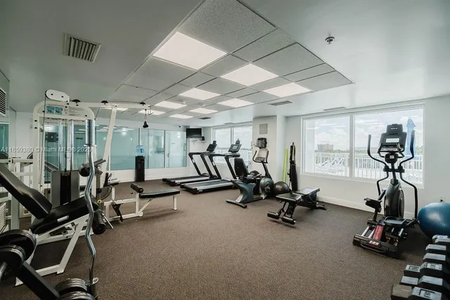 a large white kitchen with stainless steel appliances a large window