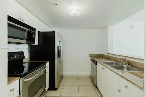 a kitchen that has a sink and a stove top oven