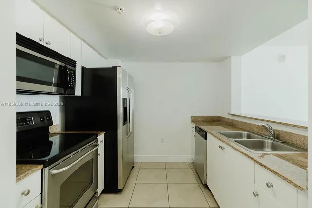 a kitchen that has a sink and a stove top oven