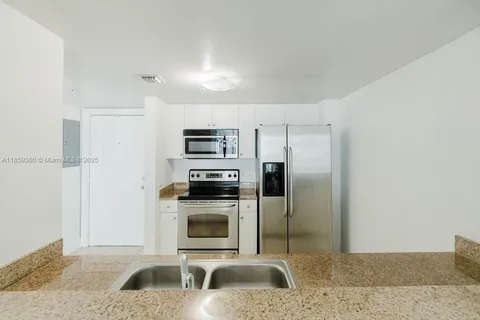 a kitchen with stainless steel appliances granite countertop a refrigerator sink and stove