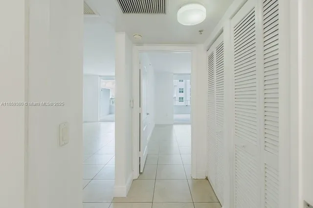 a bedroom with a bed a mirror and lamp