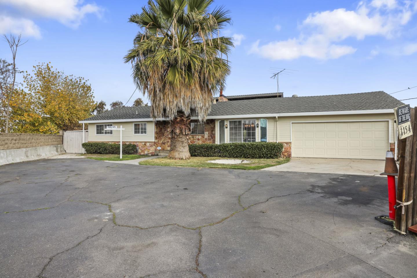 a view of a house with a yard and palm trees
