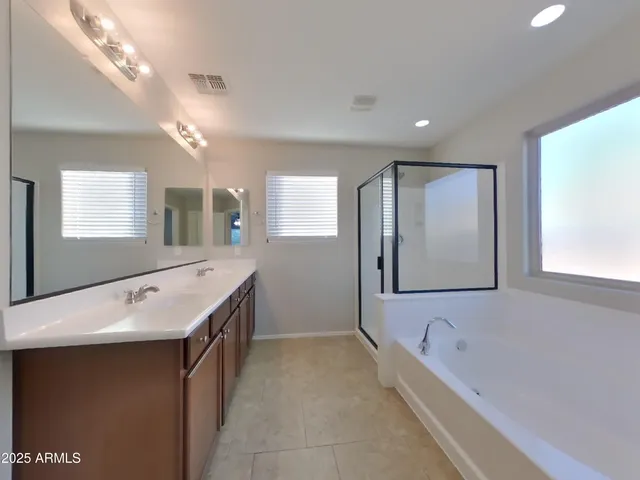 a bathroom with a tub sink and mirror