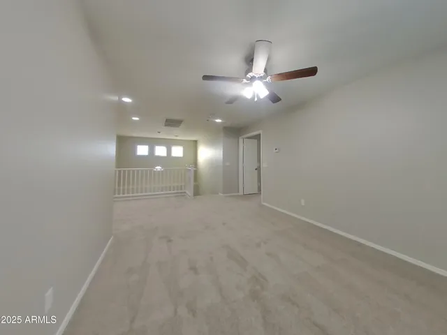 a view of an empty room with a chandelier fan