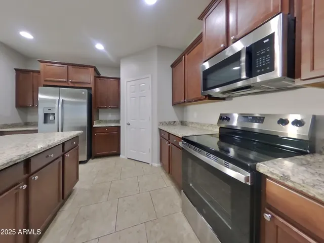a kitchen with stainless steel appliances granite countertop wooden cabinets granite counter tops and a stove
