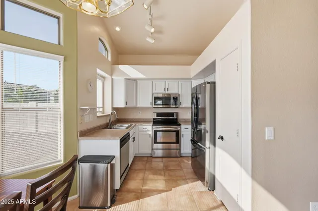 a kitchen with stainless steel appliances granite countertop a refrigerator and a stove top oven