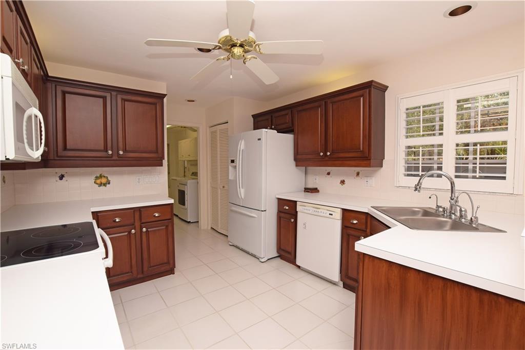 107 Napa Ridge Way Naples, FL 34119 - Photo 14 of 26 a kitchen with stainless steel appliances granite countertop a sink dishwasher stove and refrigerator
