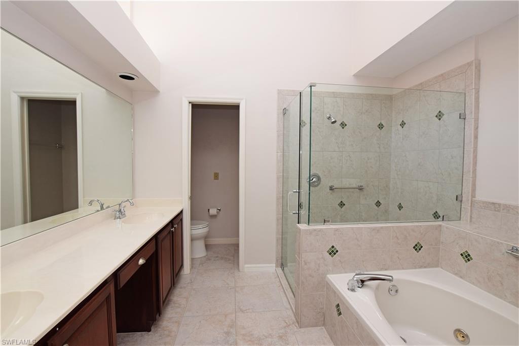 107 Napa Ridge Way Naples, FL 34119 - Photo 21 of 26 a bathroom with a tub a sink and a mirror