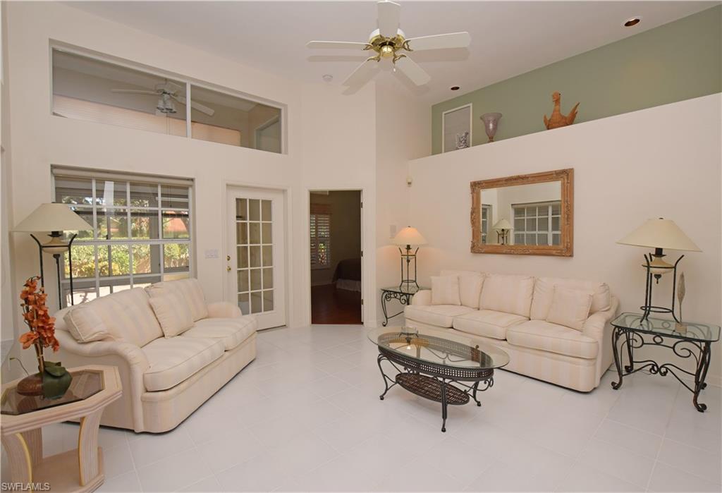 107 Napa Ridge Way Naples, FL 34119 - Photo 4 of 26 a living room with furniture and a chandelier
