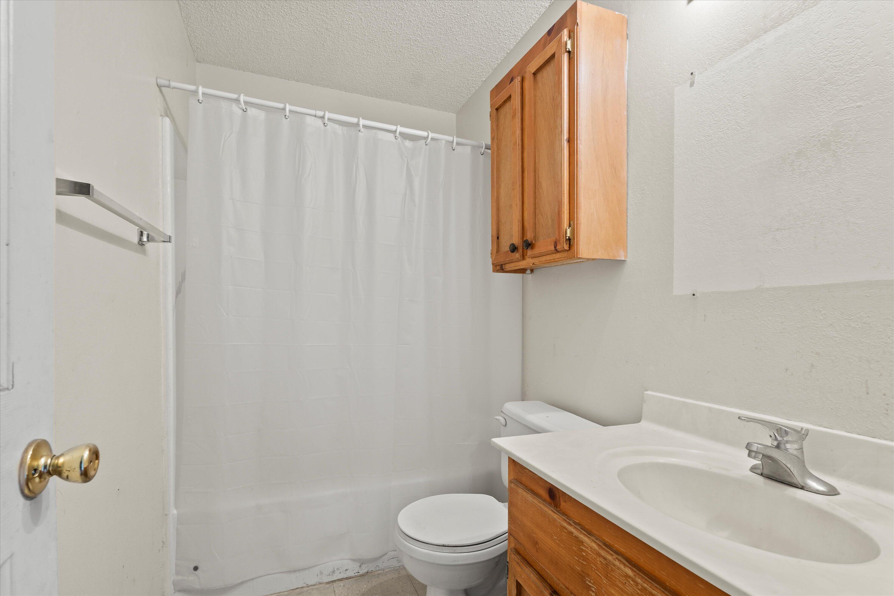 1605 Corpus Avenue Wolfforth, TX 79382 - Photo 14 of 20 a bathroom with a sink a toilet and shower curtain