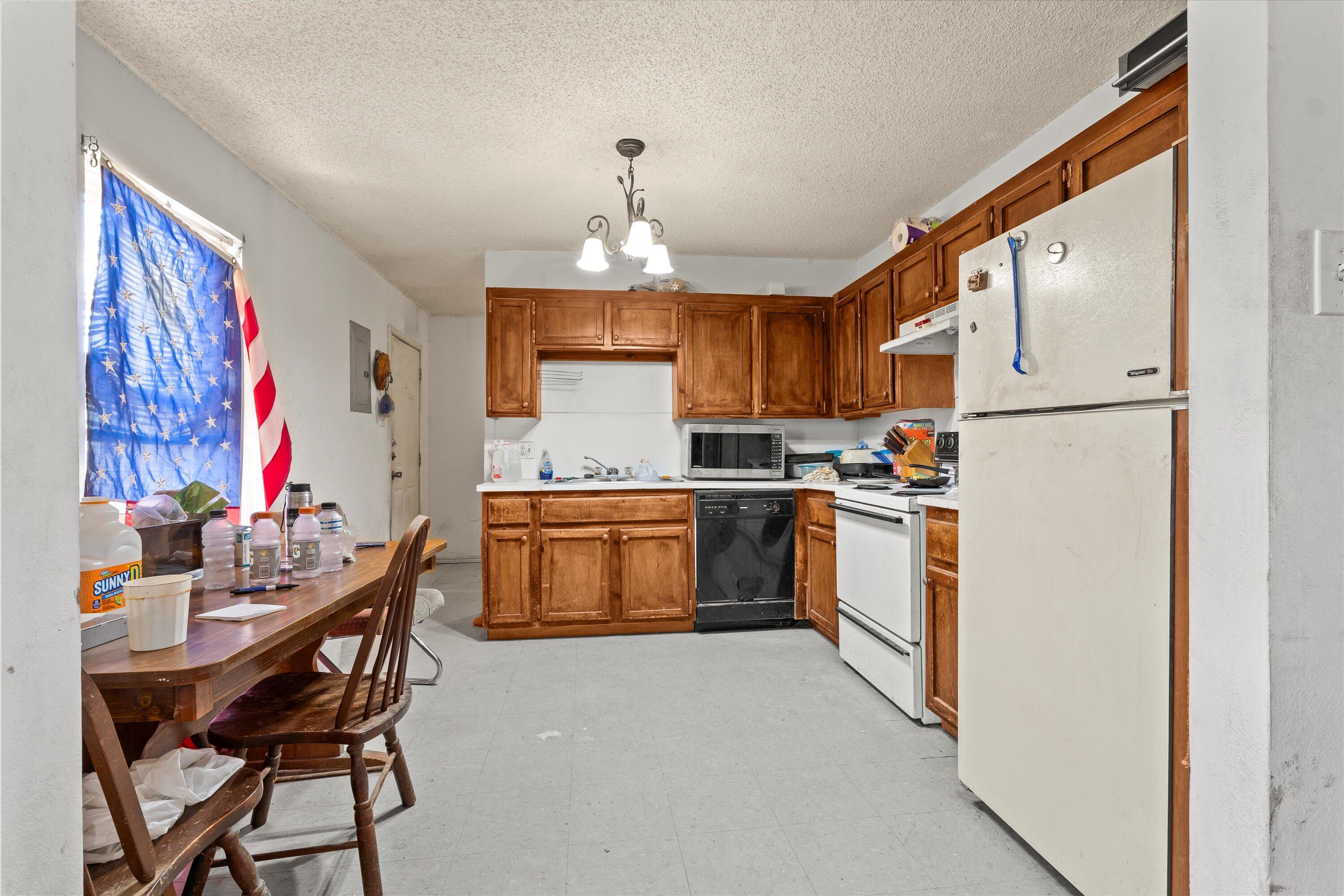 1605 Corpus Avenue Wolfforth, TX 79382 - Photo 7 of 20 a kitchen with a refrigerator a stove a sink dishwasher and cabinets with wooden floor