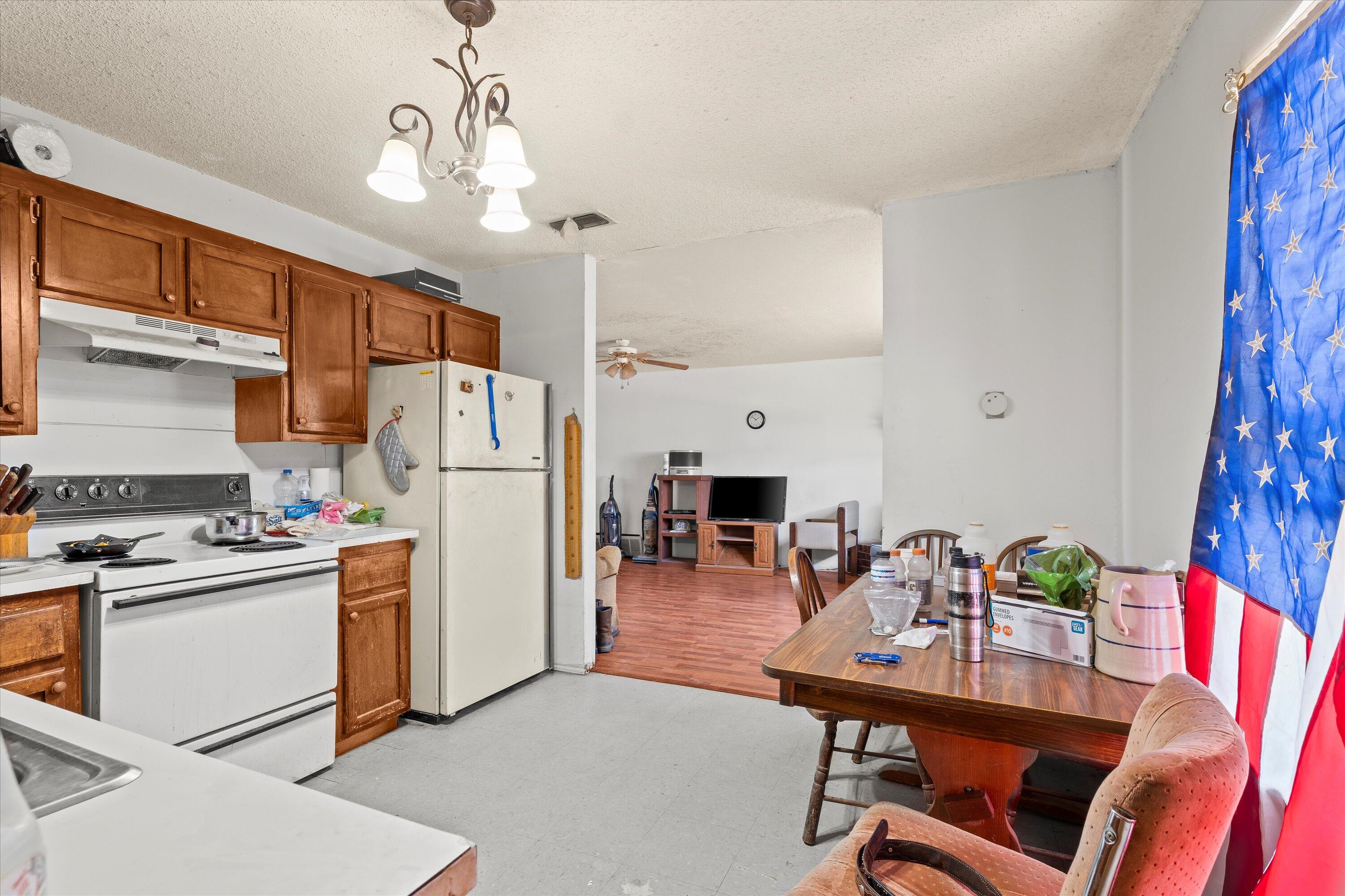 1605 Corpus Avenue Wolfforth, TX 79382 - Photo 8 of 20 a kitchen with stainless steel appliances a refrigerator a stove a dining table and chairs with wooden floor