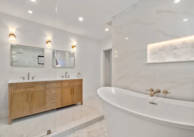 a bathroom with a tub a sink and mirror
