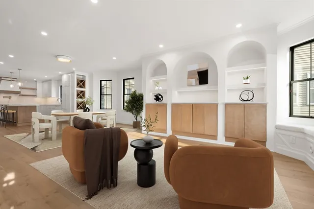 a living room with furniture a large window and wooden floor