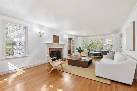 a dining room with wooden floor a chandelier a glass table and chairs