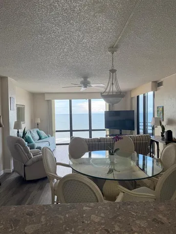 a living room with fireplace furniture and a large window
