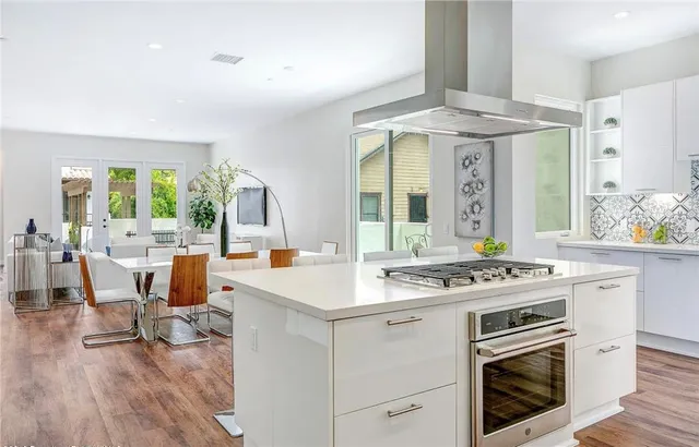 a kitchen with a stove and chairs