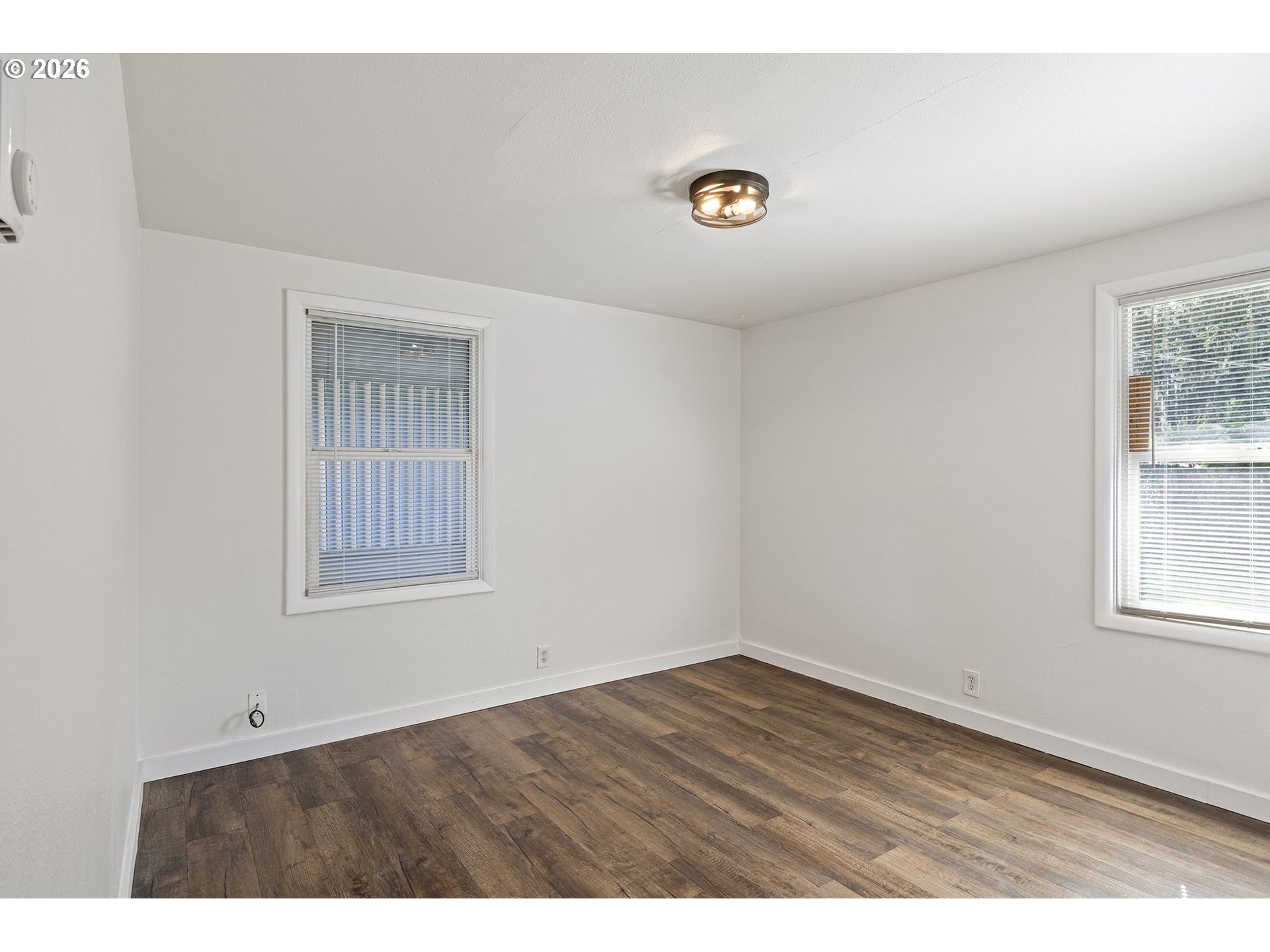 1008 Coburg Road Eugene, OR 97401 - Photo 17 of 46 an empty room with wooden floor and windows