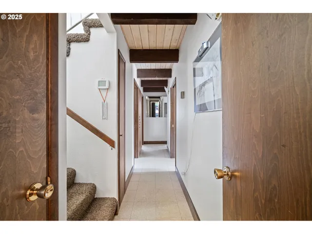 a view of a hallway with wooden floor and staircase
