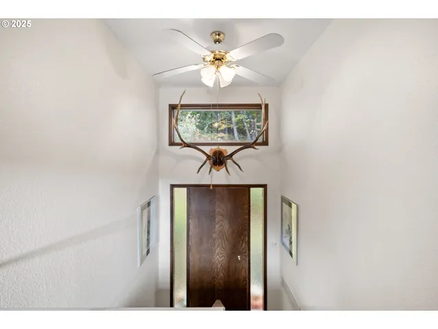 a view of a hallway with a chandelier fan