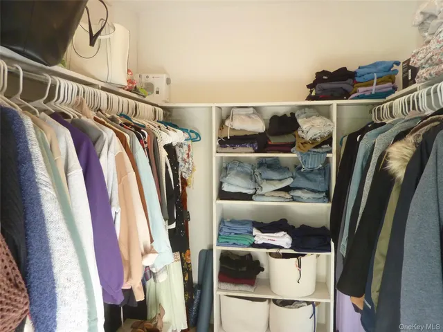 a view of walk in closet with clothes and shoes