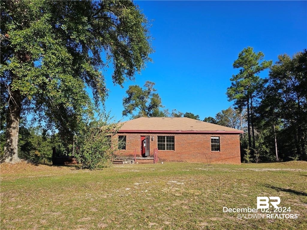 10230 Sand Ridge Road Chunchula, AL 36521 - Photo 1 of 1 Back of house with a lawn