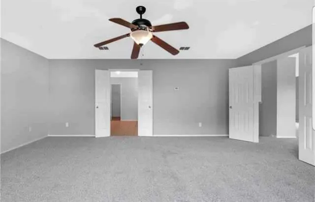 a view of an empty room with a ceiling fan