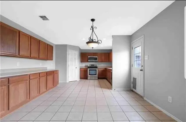 a kitchen with granite countertop a stove top oven and cabinets