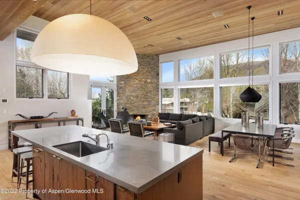 a kitchen with a stove a counter space a sink and living room view