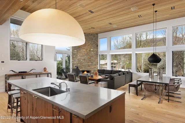 a kitchen with a stove a counter space a sink and living room view