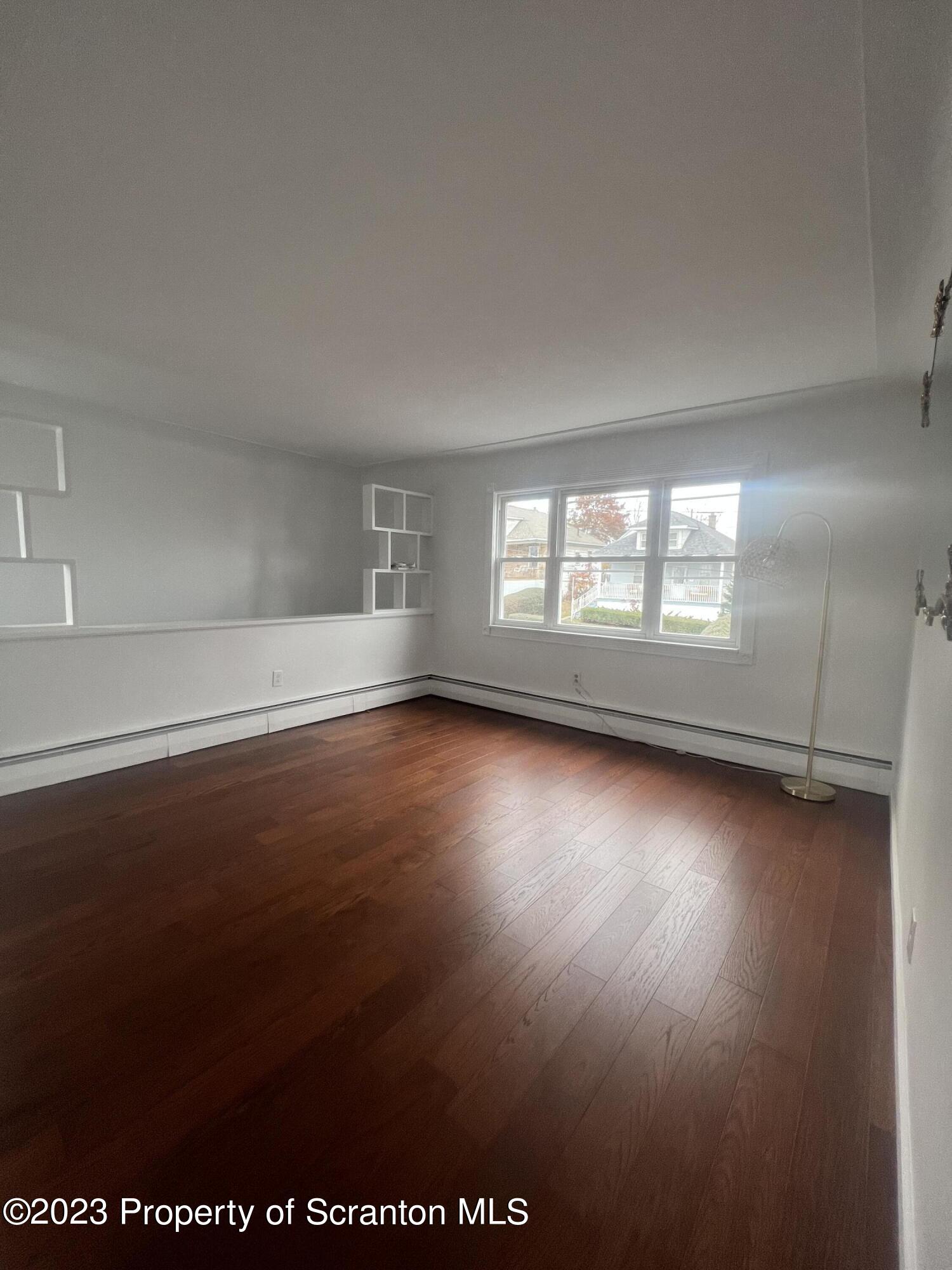 1151 Amherst Street Scranton, PA 18504 - Photo 3 of 11 an empty room with wooden floor and windows