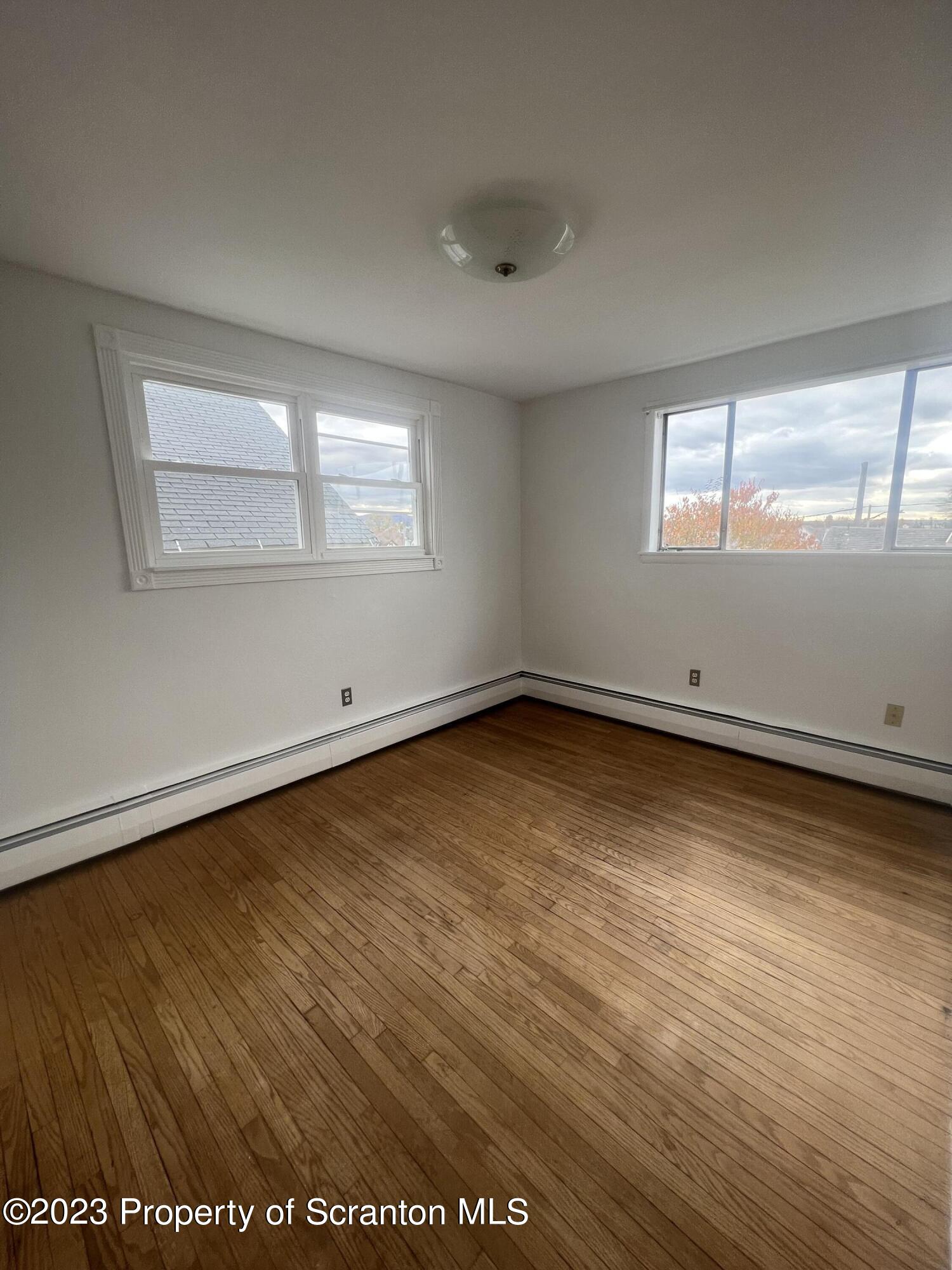 1151 Amherst Street Scranton, PA 18504 - Photo 10 of 11 an empty room with wooden floor and windows
