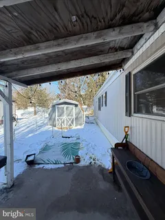 a backyard of a house with large trees and wooden fence