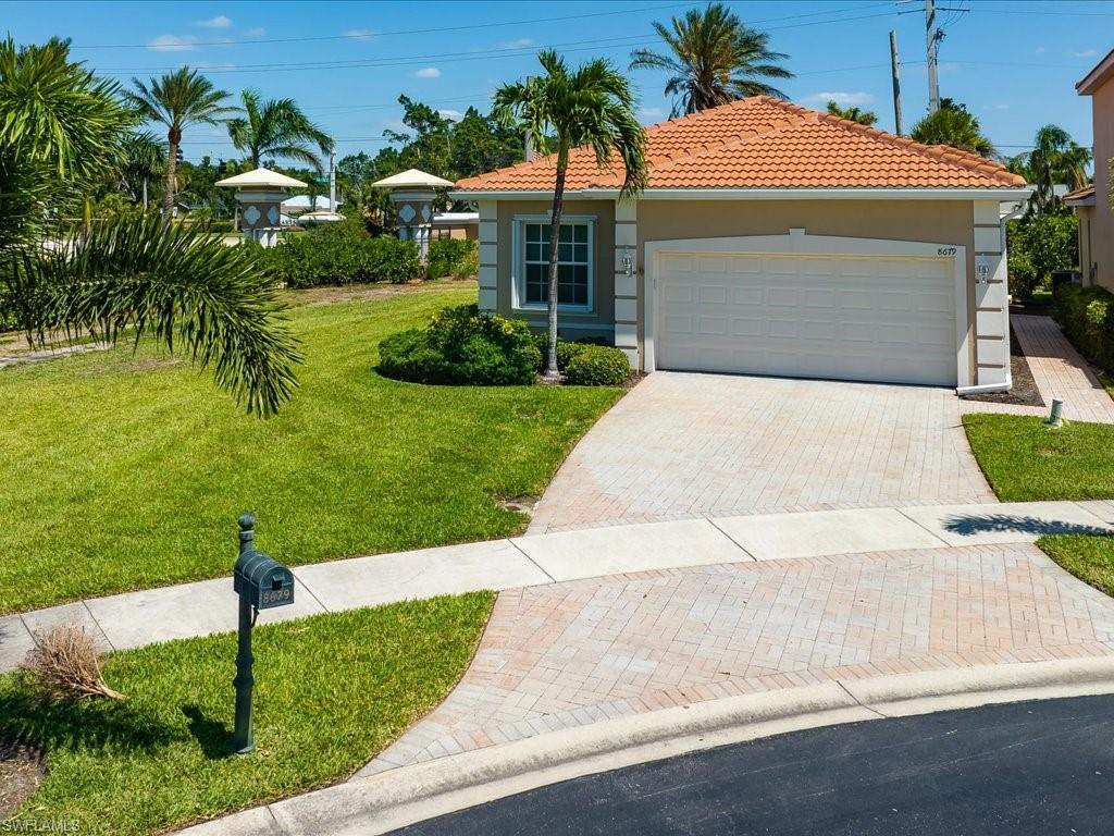 a front view of a house with a yard and potted plants