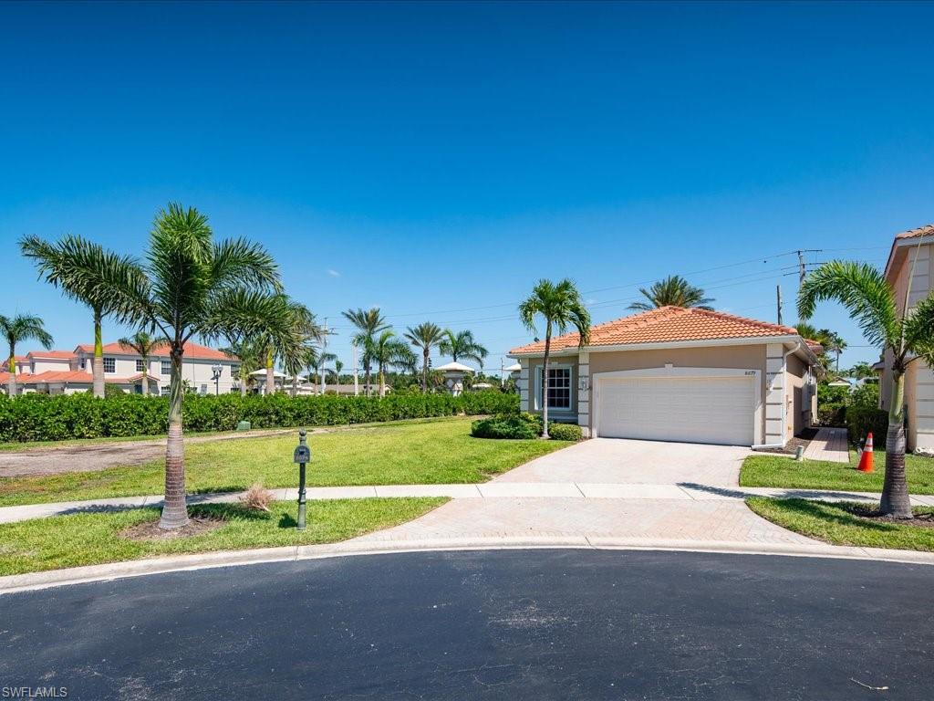 8679 Spring Mountain Way Fort Myers, FL 33908 - Photo 19 of 21 a front view of a house with a yard and palm tree
