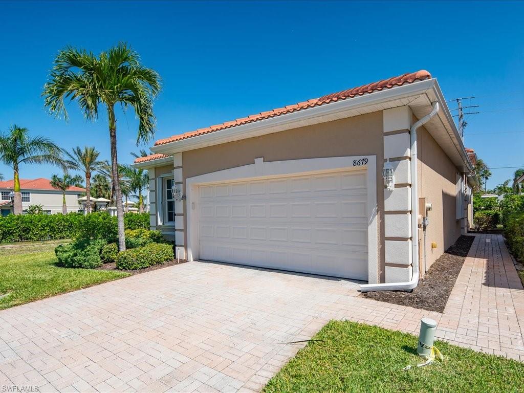 8679 Spring Mountain Way Fort Myers, FL 33908 - Photo 2 of 21 a front view of a house with a garage