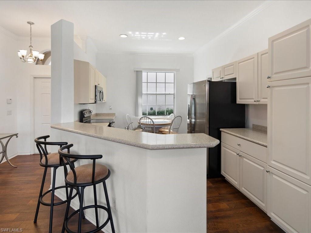 8679 Spring Mountain Way Fort Myers, FL 33908 - Photo 6 of 21 a kitchen with kitchen island a appliances dining table and chairs