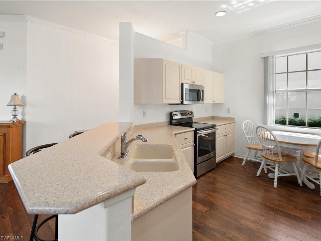 8679 Spring Mountain Way Fort Myers, FL 33908 - Photo 7 of 21 a kitchen with a sink cabinets and wooden floor