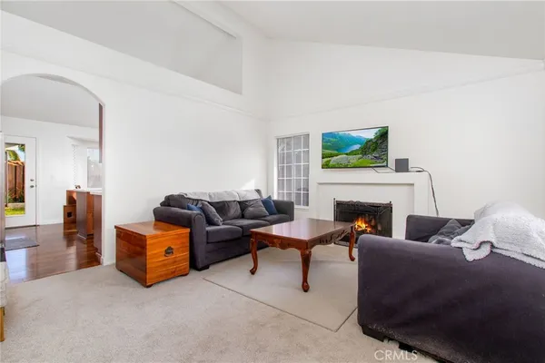 a living room with furniture a flat screen tv and a fireplace