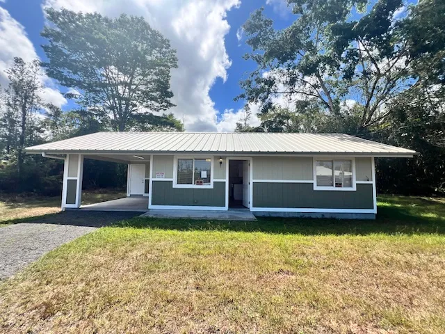 a front view of a house with a garden and yard